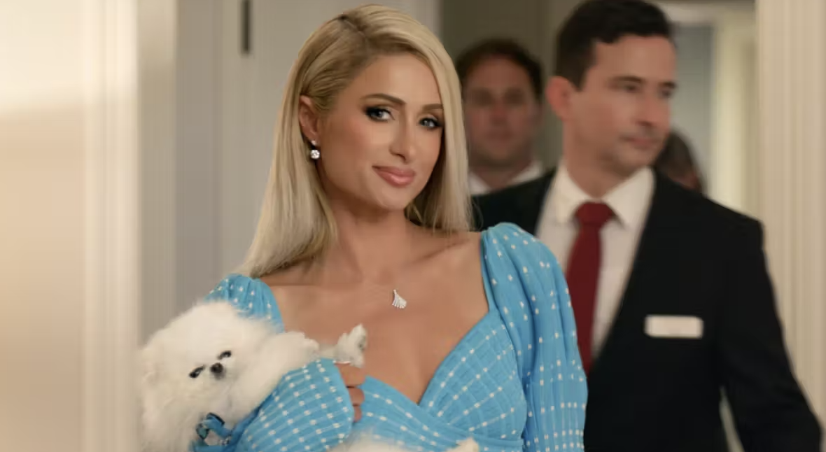 Paris Hilton in a blue dress holding her white dog